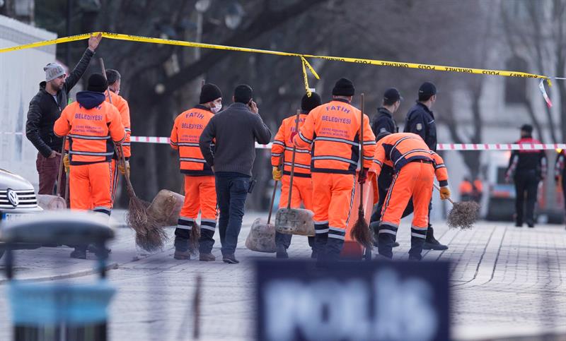 Un grupo de trabajadores comienza a limpiar el lugar de los hechos después de que la investigación policial concluyera tras el atentado suicida perpetrado en el turístico distrito de Sultanahmet, en el centro de Estambul (Turquía)