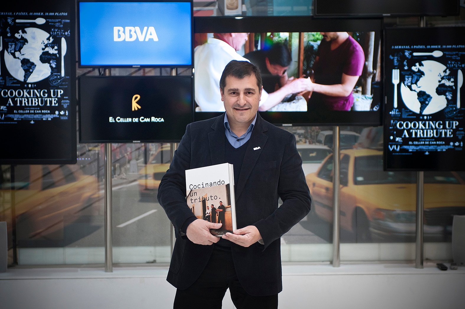 Fotografía de Josep Roca con el libro 'Cocinando un tributo', sobre la primera gira BBVA- El Celler de Can Roca