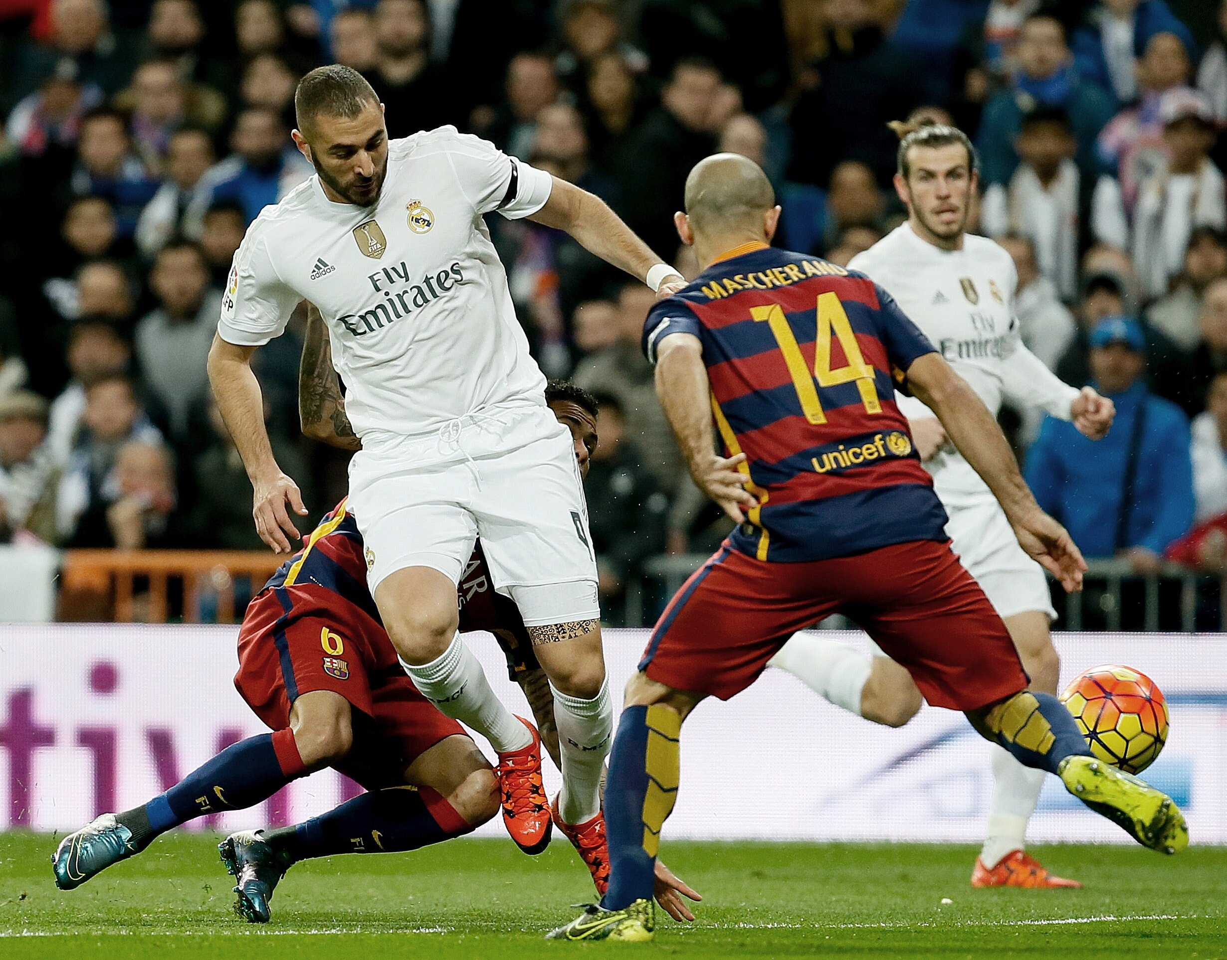 El delantero francés del Real Madrid Karim Benzema (i) pelea un balón con el defensa argentino del FC Barcelona Javier Mascherano en partido de Liga BBVA de la jornada 12º que les enfrenta en el Estadio Santiago Bernabéu. EFE