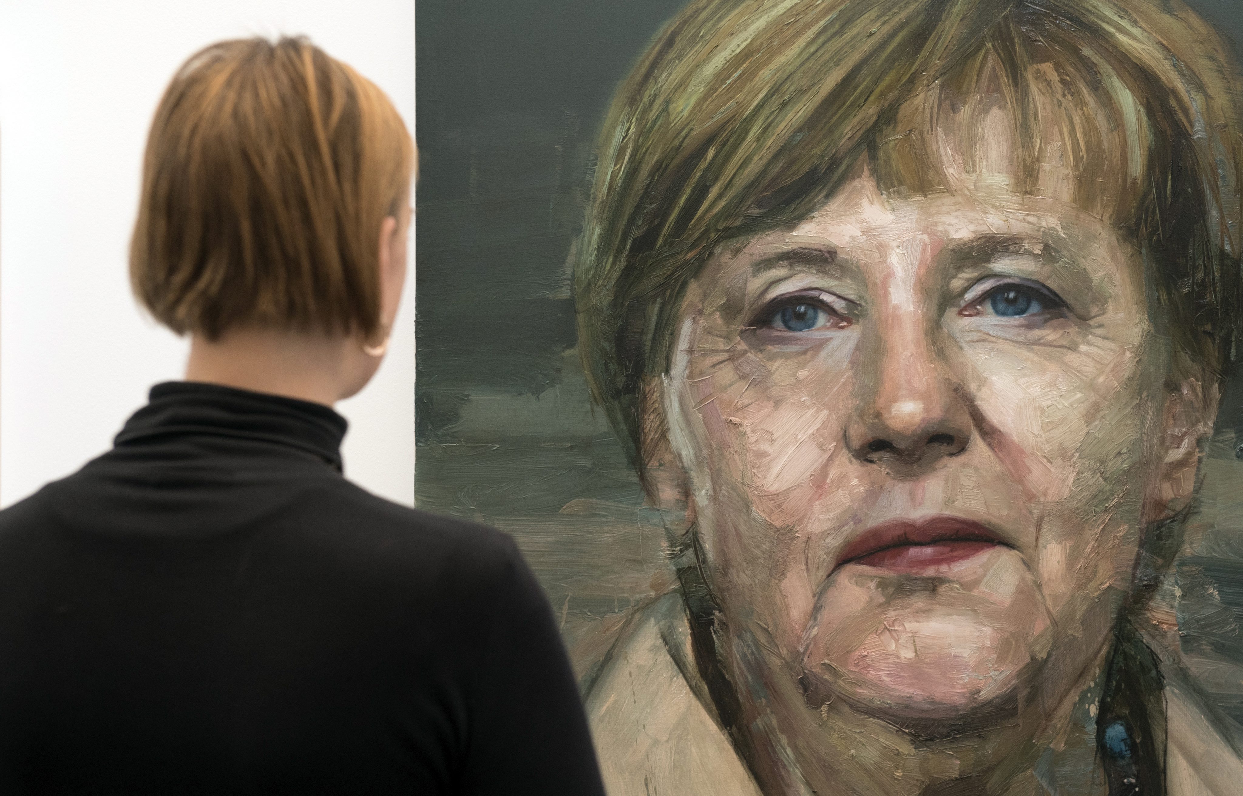 R.UNIDO ARTE LONDRES:WOL005 LONDRES (REINO UNIDO) 19/01/2016.- Una contempla el retrato de la canciller alemana, Angela Merkel, realizado por el artista irlandés Colin Davidson, durante la Feria de Arte de Londres (Reino Unido), el 19 de enero de 2016. La Feria de Arte londinense se celebra del 20 al 24 de enero. EFE/Will Oliver