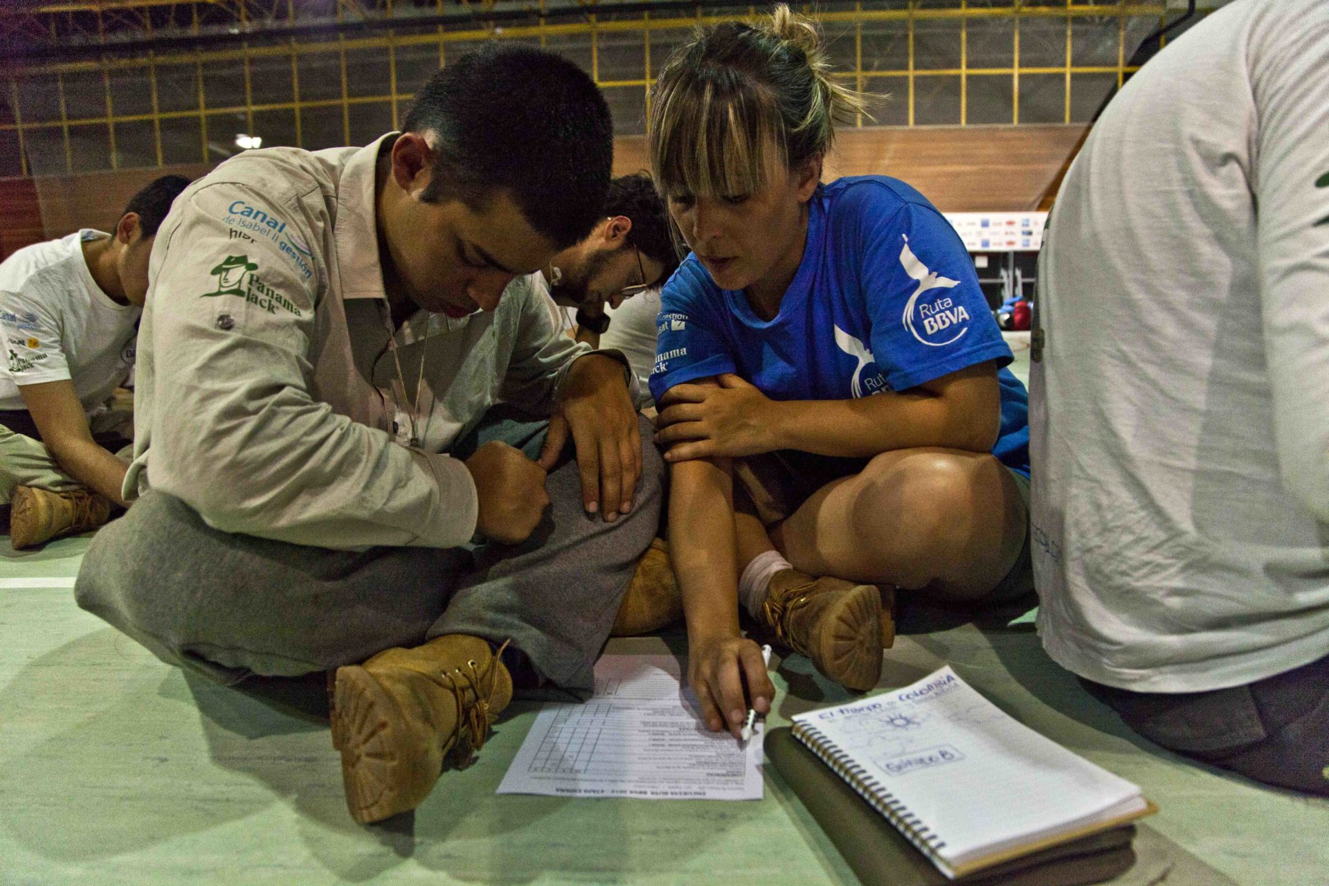 Fotografía: Adrián Rincón rellena un formulario con ayuda de su monitora en Ruta BBVA 2015