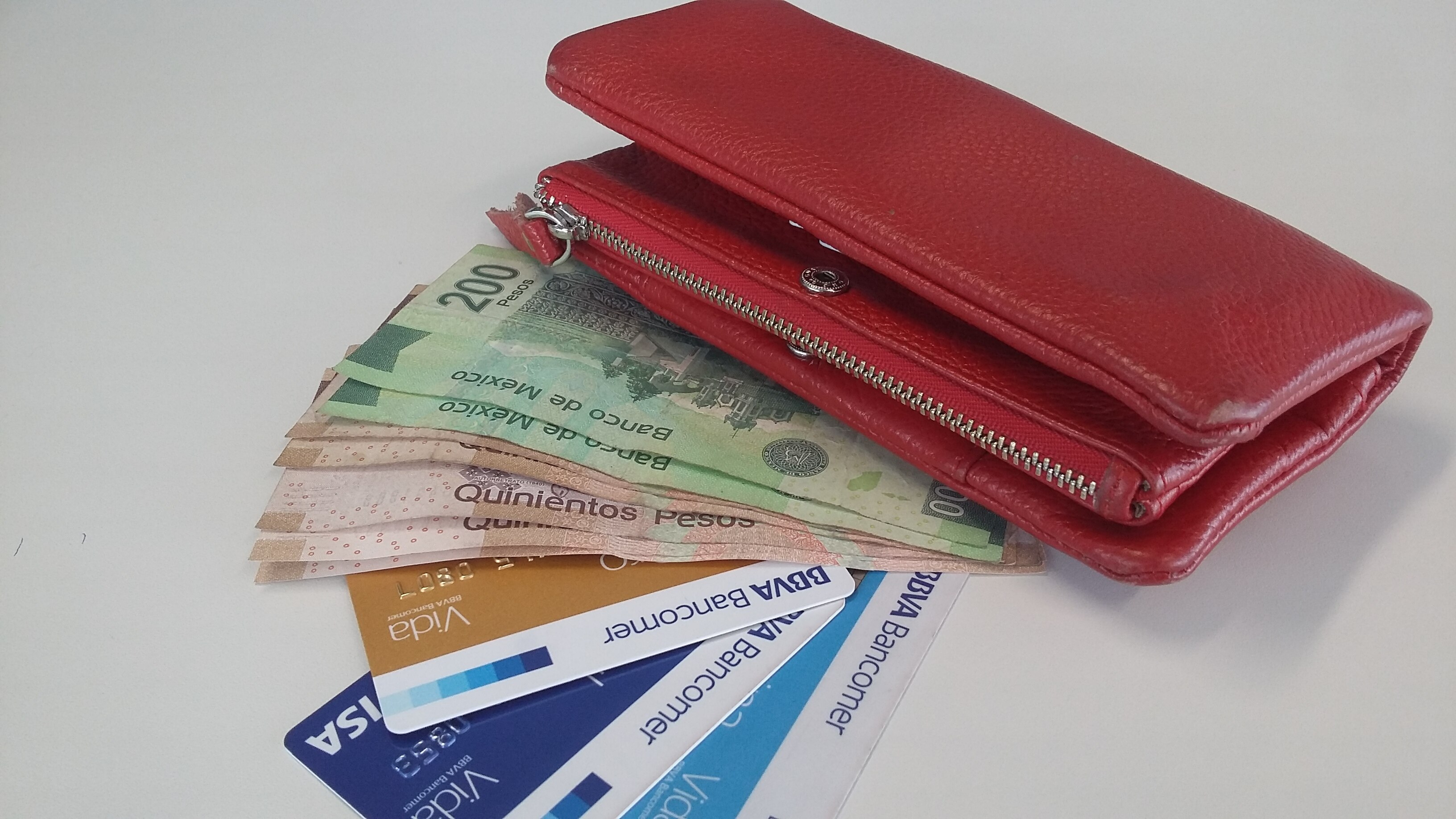 Cartera roja con billetes pesos y tarjetas BBVA Bancomer México