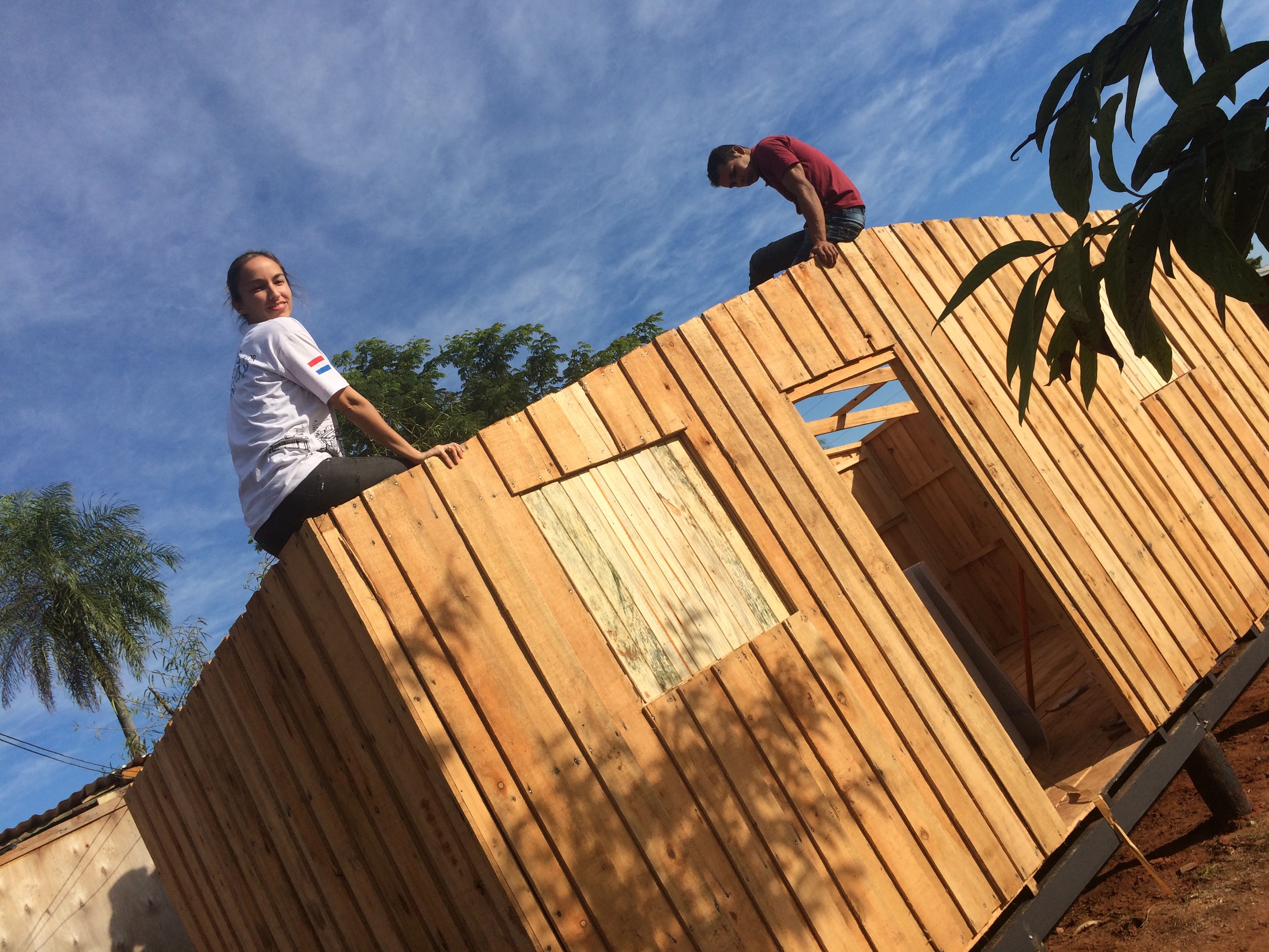 Voluntarios posan en vivienda en construcción Construyendo con Techo