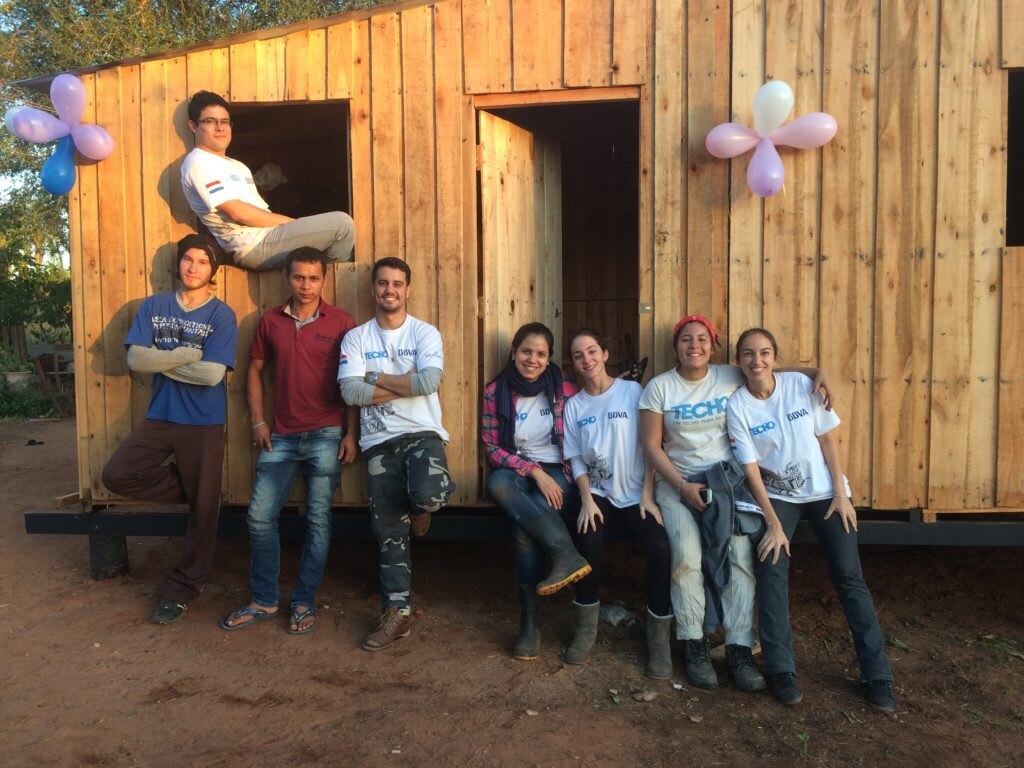 Voluntarios frente a vivienda terminada Voluntarios posan frente a vivienda