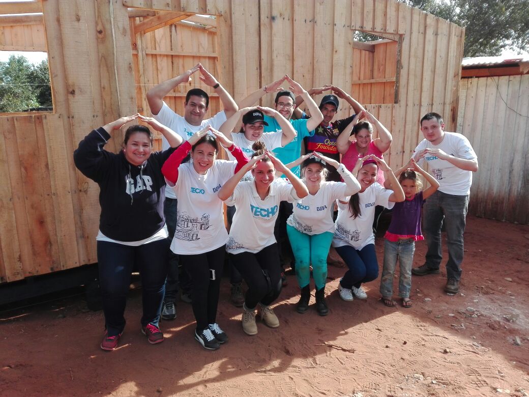 Voluntarios BBVA posan frente a vivienda en construcción Construcción de viviendas con Techo