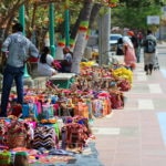 Foto de una calle de Colombia donde un grupo de personas venden mochilas, bolsos y hamacas tejidos a mano - Fundación Microfinanzas BBVA