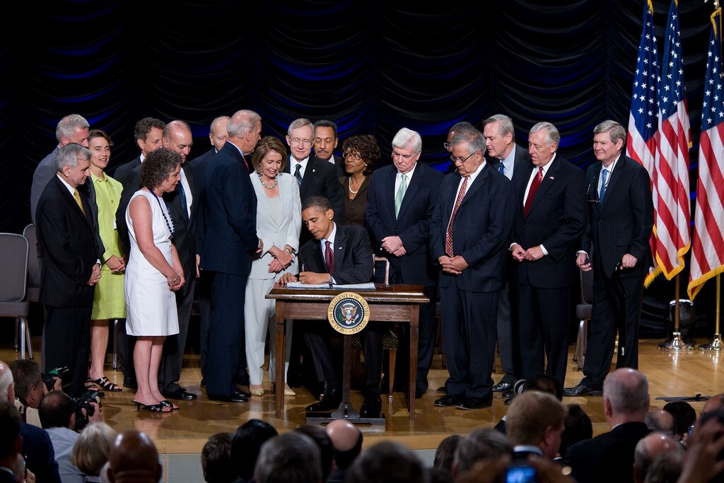 Obama firma la Ley Dodd-Frank de Protección al Consumidor y Reforma de Wall Street junto a miembros del congreso, su administración, Nancy Pelosi y el Vicepresidente Joe Biden, en Washington. Obama firma la Ley Dodd-Frank