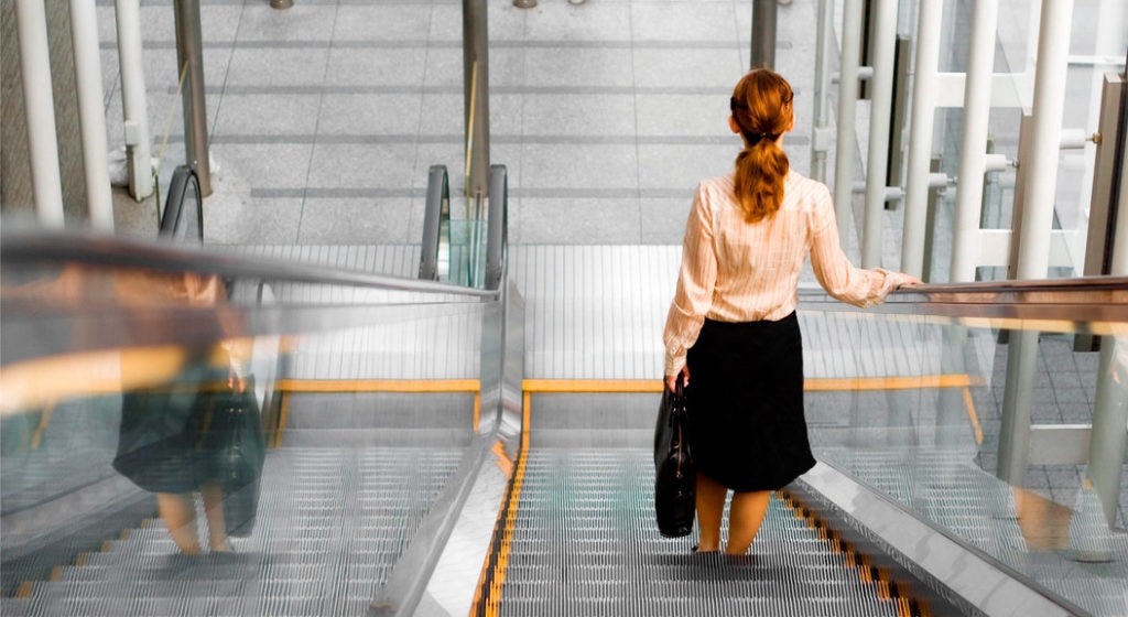 Mujer. Escaleras mecánicas. Espalda. Recurso. Fotografía de una mujer de espaldas