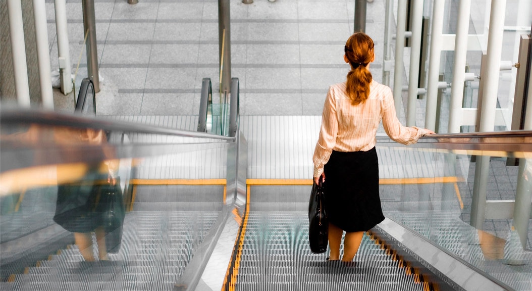 Mujer. Escaleras mecánicas. Espalda. Recurso. Fotografía de una mujer de espaldas