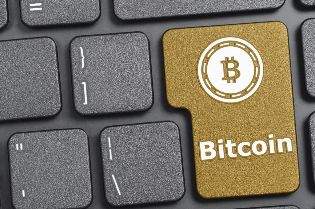 Bitcoin es más que una moneda virtual Fotografía de teclado con una Bitcoin, moneda virtual