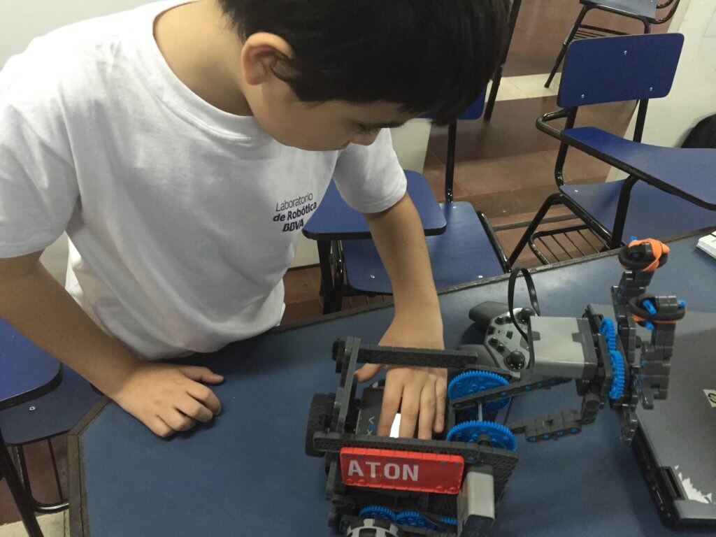 Niño con su robot Niño verificando su robot