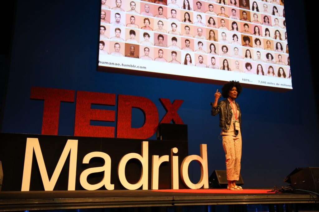 Angélica Dass con Humanae de fondo durante su participación en TEDxMadrid 2013 Angélica Dass con Humanae de fondo durante su participación en TEDxMadrid 2013