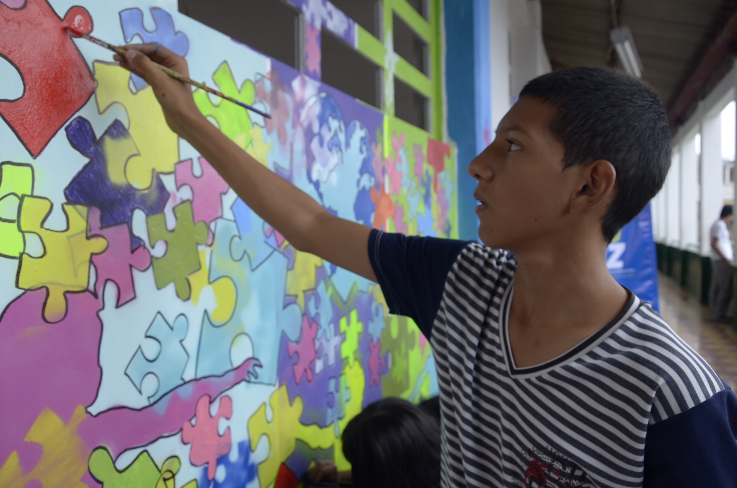 Estudiante de la Rafael Uribe Uribe pintando un mural de rompecabezas Fotografía de Estudiante de la Rafael Uribe Uribe pintando un mural de rompecabezas