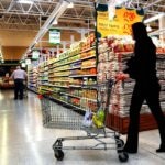 Fotografía de Mujer conduciendo un carrito de compras en un supermercado