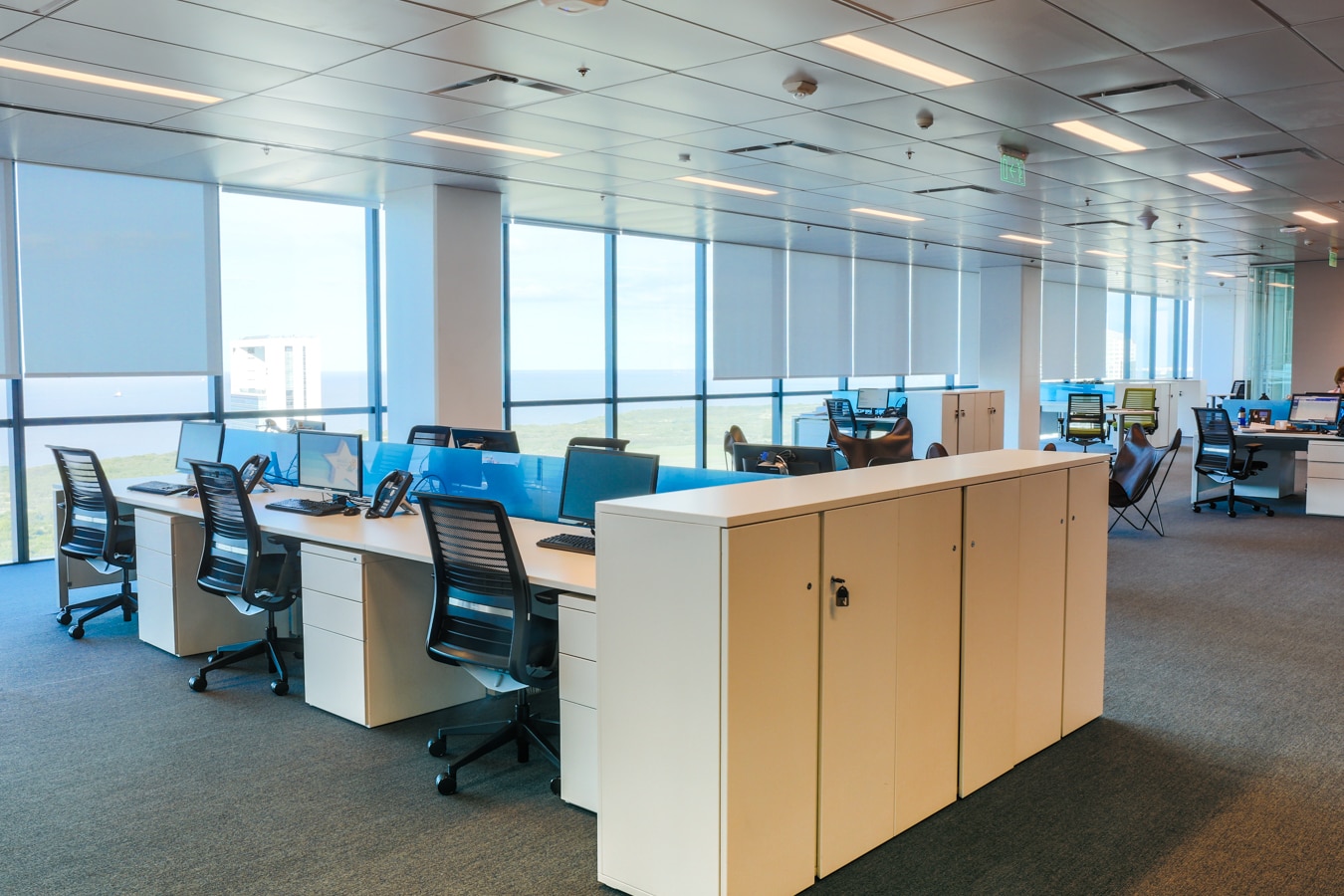 Espacio personal compuesto por un escritorio en bench una silla ergonómica de última generación y monitores regulados a la altura recomendada. Torre BBVA, casa central de BBVA Francés, Buenos Aires Espacio de trabajo - Open Space - Torre BBVA