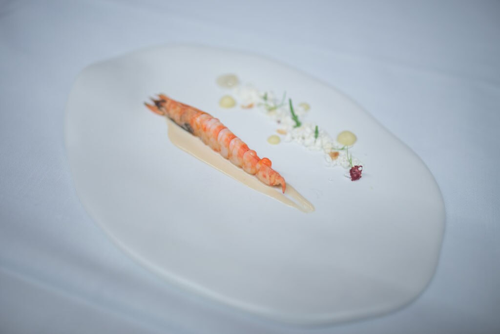 Gira BBVA - Langostino de Sanlúcar de Barrameda con albariza de ajos, uvas de manzanilla, compota de manzana, almendra tierna y salicornia Gira BBVA - Langostino de Sanlúcar de Barrameda con albariza de ajos, uvas de manzanilla, compota de manzana, almendra tierna y salicornia