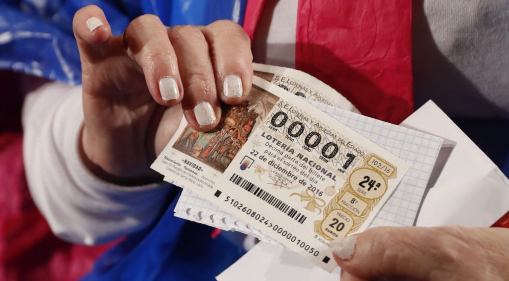 ESPAÑA LOTERIA NAVIDAD:GRA009 MADRID, 22/12/2016.-El Teatro Real acoge El Sorteo Extraordinario de Navidad, en el que aficionados, curiosos y personajes de lo más variopinto ataviados con disfraces hacen cola desde la madrugada para vivir en directo el ritual de los números y los premios cantados por los niños de San Ildefonso. El sorteo, el más antiguo y popular de los que tienen lugar en España. repartirá 2.310 millones de euros, entre los 165 millones de décimos que se han puesto a la venta.En la foto,una persona enseña su décimo antes del sorteo. EFE/Ballesteros ESPAÑA LOTERIA NAVIDAD