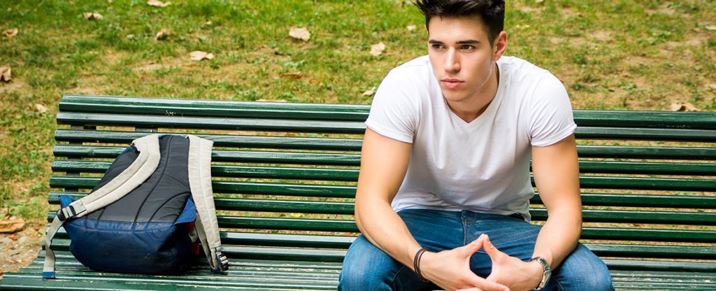 Joven sentado en un banco. Informe Fundación BBVA sobre abandono escolar jóvenes españoles Imagen informe Fundación BBVA sobre abandono escolar jóvenes españoles