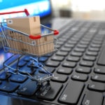 E-commerce. Shopping cart with cardboard boxes on laptop. 3d