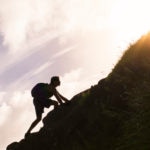 fotografía de hombre escalando montaña verde BBVA