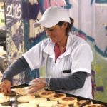 Dary Guerrero, emprendedora de la Fundación Microfinanzas BBVA, en su puesto de arepas con queso Dary Guerrero, emprendedora de la Fundación Microfinanzas BBVA, en su puesto de arepas con queso