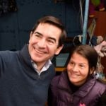 Fotografía del presidente de BBVA, Carlos Torres Vila, con Jéssica Hernández y su hija en su taller de costura