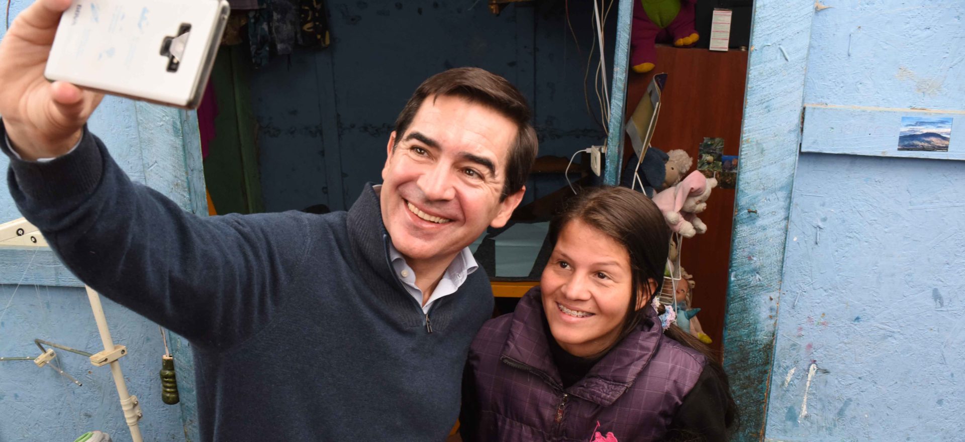 Fotografía del presidente de BBVA, Carlos Torres Vila, con Jéssica Hernández y su hija en su taller de costura