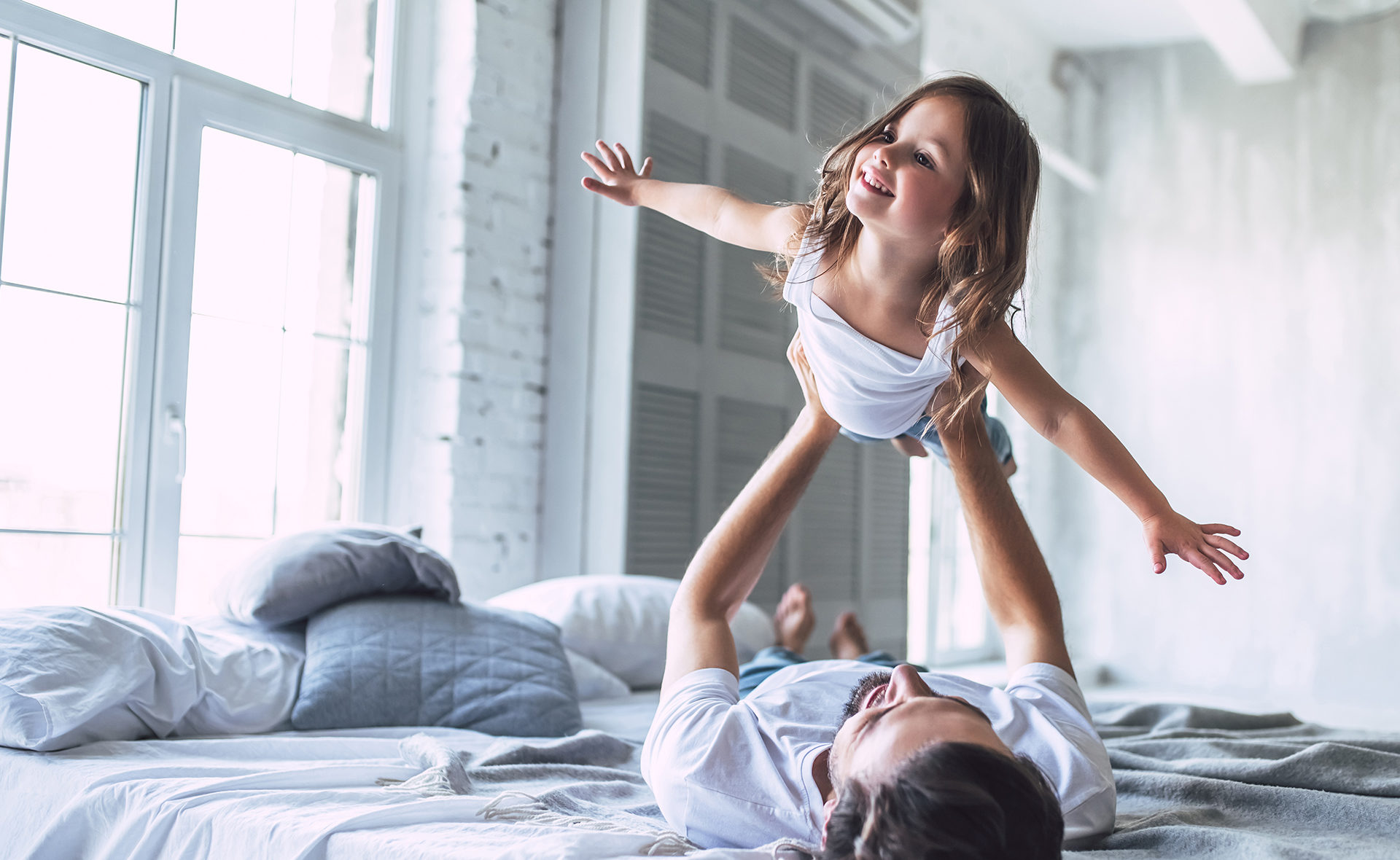Apertura-dia-niña-educación-financiera-familia-hija-volar-cama-padres