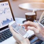 Businesswoman analyzing stock market KPI with BI, computer, smartphone screen
