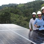 La ingeniera Yuliany García, acompañada de sus socias en la instalación de un panel en zona rural de Santander.