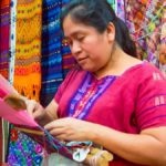 Mayan woman weaving textiles for sale in a market