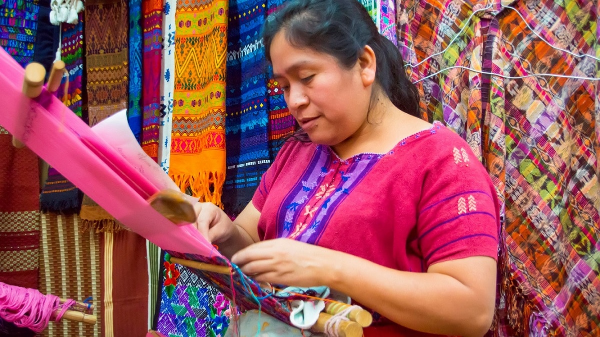 Mayan woman weaving textiles for sale in a market