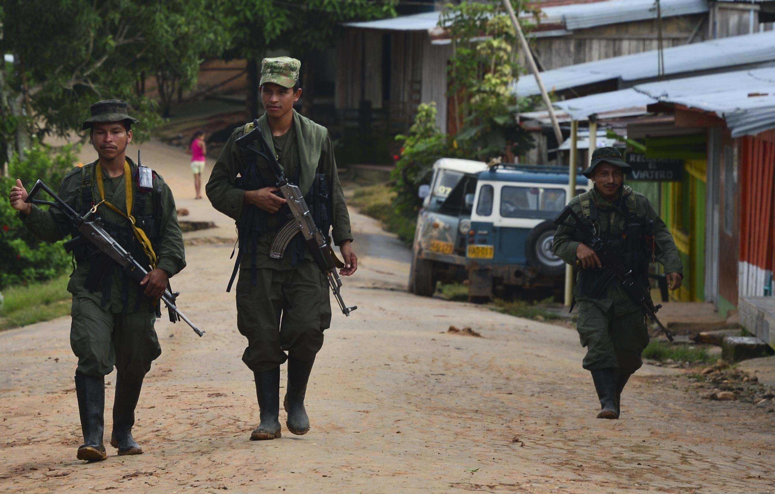 Armed FARC fighters on a trek across one of the Colombian municipalities without State presence. Image of Armed FARC fighters on a trek across one of the Colombian municipalities without State presence.
