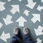 Body-image-Using-mental-models-to-make-better-decisions Taking decisions for the future man standing with many direction arrow choices, left, right or move forward